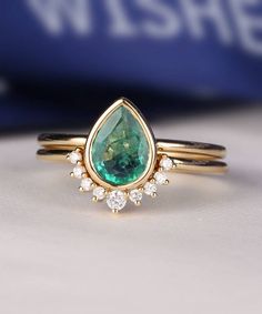 a close up of a ring with a green and white stone in the center on a table