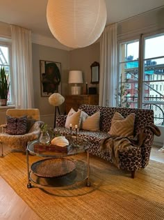 a living room with two couches and a coffee table in front of large windows