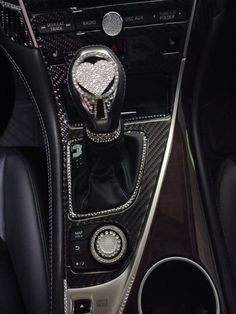 the interior of a car with black leather and silver trims, including an automatic gear lever