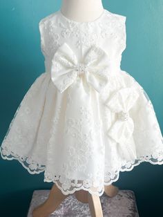 Baby girl white Christening dress / Occasion Dress, Embroidered lace bodice, and white lace waist sash with button fastening to back. Big bow to the front with delicate diamante detailing in the middle. Matching headband to the bow on the dress. Gorgeous quality outfit.  This baby girls Christening / Baptism outfit in a classic traditional style is perfect for a special occasion and can also be ideal to wear as a special outfit for a communion, wedding, bridesmaid or naming ceremony. OUR POLICY Cream Wedding Dress With Bow, Elegant Floral Applique Dress For Ceremony, Elegant Floral Applique Ceremony Dress, Elegant Ceremony Dress With Floral Applique, White Lace Patchwork Princess Dress For Wedding, White Princess Dress With Satin Bow For Baptism, White Lace First Communion Dress With Floral Applique, Elegant Lace First Communion Dress With Floral Applique, White Lace Patchwork Princess Wedding Dress