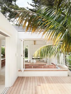 an outdoor hot tub in the middle of a wooden deck with palm trees behind it