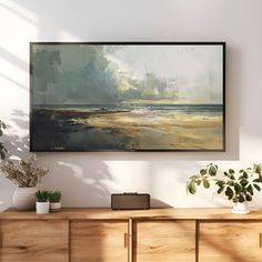 a painting hanging on the wall above a wooden dresser with potted plants next to it