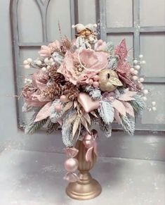 a gold vase filled with lots of different types of flowers