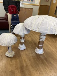 two white mushrooms sitting on top of a hard wood floor