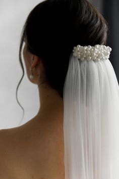 the back of a woman's head wearing a veil with pearls on it