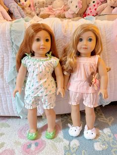 two dolls standing next to each other in front of a bed full of stuffed animals