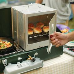 a person is cooking food on an outdoor grill