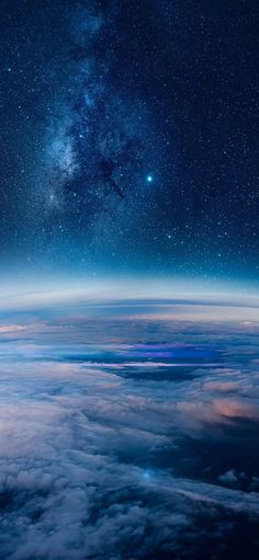 the night sky is filled with stars and clouds, as seen from an airplane window