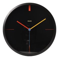 a black clock with red, yellow and blue hands