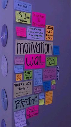 a bulletin board covered in sticky notes with motivational words and phrases attached to it