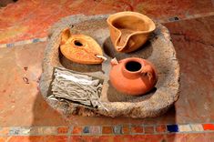 an assortment of pottery is displayed on a stone tray