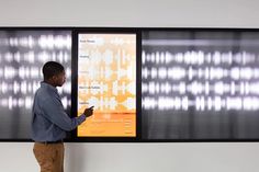 a man standing in front of a large display with sound waves on it's walls