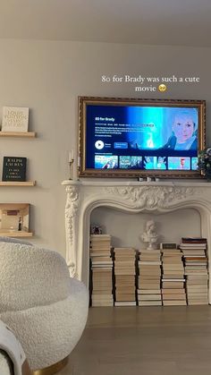 a living room with a fireplace, tv and books on the shelves in front of it