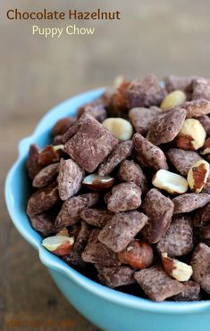 chocolate hazelnut puppy chow in a blue bowl on a wooden table with text overlay that reads chocolate hazelnut puppy chow