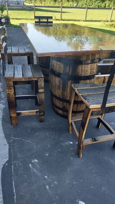 an outdoor table and chairs made out of wooden barrels