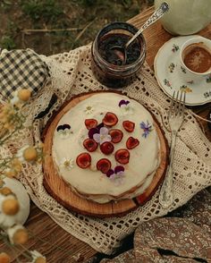 a cake sitting on top of a wooden table next to a cup and saucer