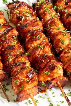 the skewers are covered with meat and garnished with green parsley