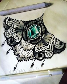 an intricate drawing with a green stone in the center and black lace around it, on top of a piece of paper