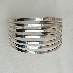 Exquisite design silver cuff bracelet made by Franz Scheurle in the 1960s. Hand crafted with an embossed textured surface. 16,5 cms in inner length, opening excluded. Openning is 2,5 cms wide. Idth in the middle central front is 3,7 cms. Hallmarked 835 S, threepass crown and makers mark FS in an oval frame. Very special! A fine example of midcentury modernist design at it's best! Suitable as a fine vintage gift for her with a taste for unique design jewelry. Pre-owned, in a good used condition. Modernist Jewelry, 60s Vintage, Silver Design, Unique Jewelry Designs, Oval Frame, Design Silver, Silver Cuff Bracelet, Shiny Silver, Silver Cuff