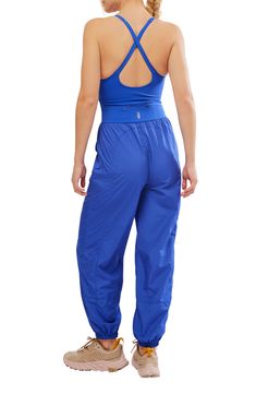 Go for a run in this one-and-done jumpsuit featuring a cutout knit tank with cross-back straps and eased-fit woven track pants. 56" length; 29" inseam; 11" leg opening (size Medium) Partially lined Scoop neck Front slant pockets; back zip pocket Elastic cuffs 68% nylon, 32% elastane with 100% polyester pants Machine wash, tumble dry By Free People; imported Sleeveless Activewear With Elastic Waistband For Workout, Spring Sportswear Parachute Pants, Sporty Parachute Pants For Summer Sports, Casual Jumpsuits And Rompers For Gym In Spring, Casual Spring Jumpsuits And Rompers For Sports, Casual Jumpsuits And Rompers For Spring Sports, Sportswear Jumpsuits And Rompers For Yoga, Sporty Summer Full-length Parachute Pants, Fitted Nylon Parachute Pants For Summer