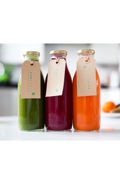 three bottles filled with liquid sitting on top of a table