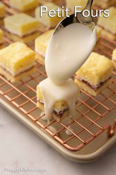 a spoon with some food on it that is being drizzled with white sauce