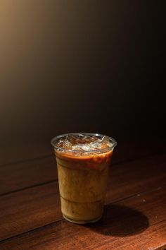 a plastic cup filled with food sitting on top of a wooden table