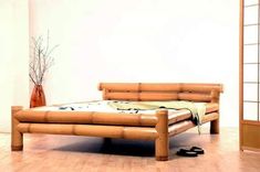 a bed made out of bamboo sticks in a room with wooden floors and white walls