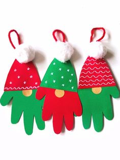 three handprinted christmas hats are hanging from red and green paper with white pom - poms