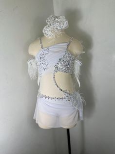 a mannequin is dressed in white and has feathers on the skirt, but no shirt