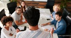 a group of people sitting around a table with papers and pens in front of them