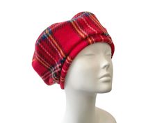 a white mannequin head wearing a red plaid hat