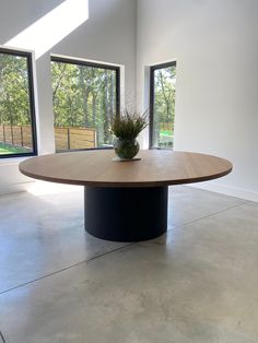 a round table in an empty room with large windows