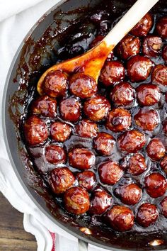 a wooden spoon in a pot filled with meatballs