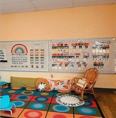 a room with colorful rugs, chairs and pictures on the wall above it is a play area for children