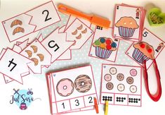 a table topped with lots of different types of doughnuts and numbers on cards