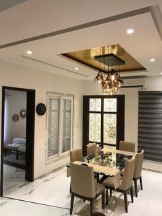 a dining room table with chairs and a chandelier hanging from it's ceiling