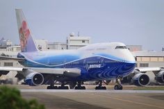 an airplane that is sitting on the tarmac with another plane in the back ground behind it