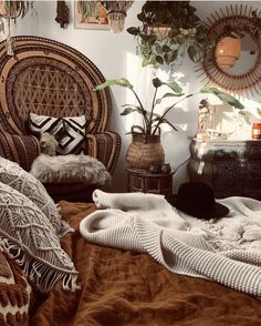 a bed with pillows and blankets on top of it in a room filled with potted plants