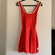 a red dress hanging on a white wall