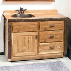 a bathroom vanity with wooden drawers and a mirror on the wall above it, along with a rug