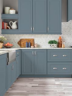 a kitchen with blue cabinets and white counter tops