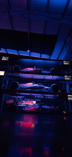 several cars are parked in a garage with blue lighting