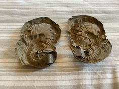 two pieces of carved clay sitting on top of a bed