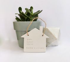 a ceramic house ornament sitting next to a potted plant