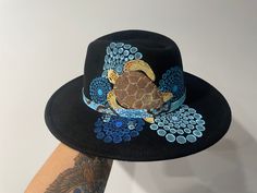 Fedora hat in black   colour adults unisex one size fits most . sea turtle hat   design hand painted by Gomerio Artist Jessica Payne. On country in Coonabarabran NSW . each  design has a beautiful story or connection . Which is sent out with the hat. many designs of custom painted available , artwork just talk with artist Hand Painted Hats Design, Handmade Black Fedora With Curved Brim, Black Wide Brim Hat As A Gift, Black Wide Brim Hat As Gift, Handmade Black Beach Hat, Black Hand-painted Hat With Curved Brim, Hand Painted Black Hat With Curved Brim, Black Hand Painted Hat With Curved Brim, Black Artistic Hat With Short Brim