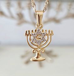 Jewish Menorah David Star Necklace, Gold Jewish Star Necklace, Jewish Jewelry, Hannukah Gift, Judaica Religious Necklaceת Jewish Necklace ♥ Each piece looks beautiful alone or great for layering.  ♥ I ensure a high-quality piece of jewelry you can wear for a long time (Please read care instructions     below).    Made with high quality of Stainless steel, 18K gold filled and real 18K gold plated tarnish resistant,     Hypoallergenic, lead and nickel free.    (This gold plated have 3x layers of solid 18k gold and are 100x times more resistant than regular gold     plated).     ♥ DESCRIPTION:    Celebrate the festival of lights with this beautiful and unique David star and menorah charms necklace.    This necklace is a perfect gift for Bat Mitzvah, birthday or Hanukkah for your loved one or Handmade Gold Star Of David Necklace, Elegant Star Of David Necklace, Hanukkah Gift Pendant Jewelry, Jewish Jewelry Jewelry Judaica, Hannukah Gift, Jewish Necklace, Jewish Star Necklace, David Star, Jewish Star