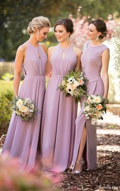 three bridesmaids in purple dresses standing next to each other