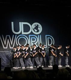 a group of young men standing on top of a stage next to each other in front of a sign