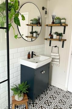 a bathroom with black and white tile flooring and shelves on the wall above the sink